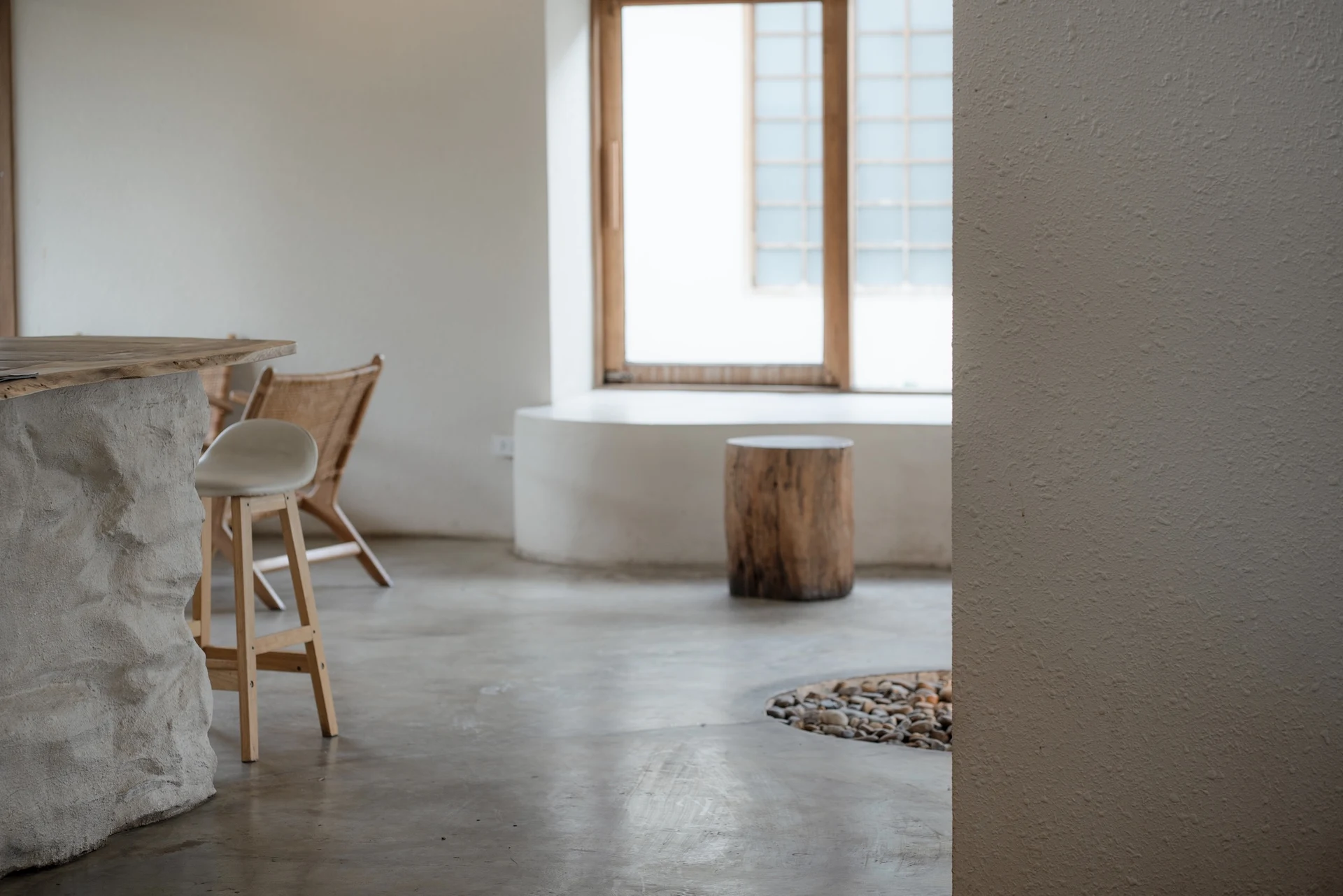 Sculptural timber furniture and natural stone, reflecting the studio’s material-led design approach